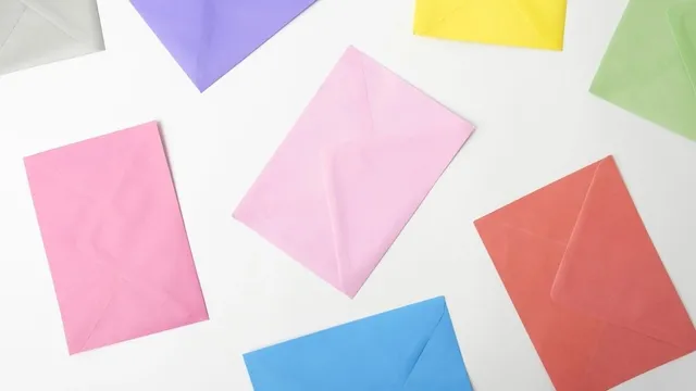 Des enveloppes de couleur, roses, bleues et jaunes, posées sur une table blanche.